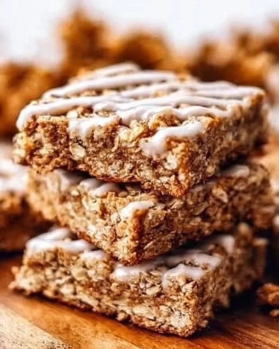 Delicious cinnamon roll oatmeal bars topped with icing on a wooden table